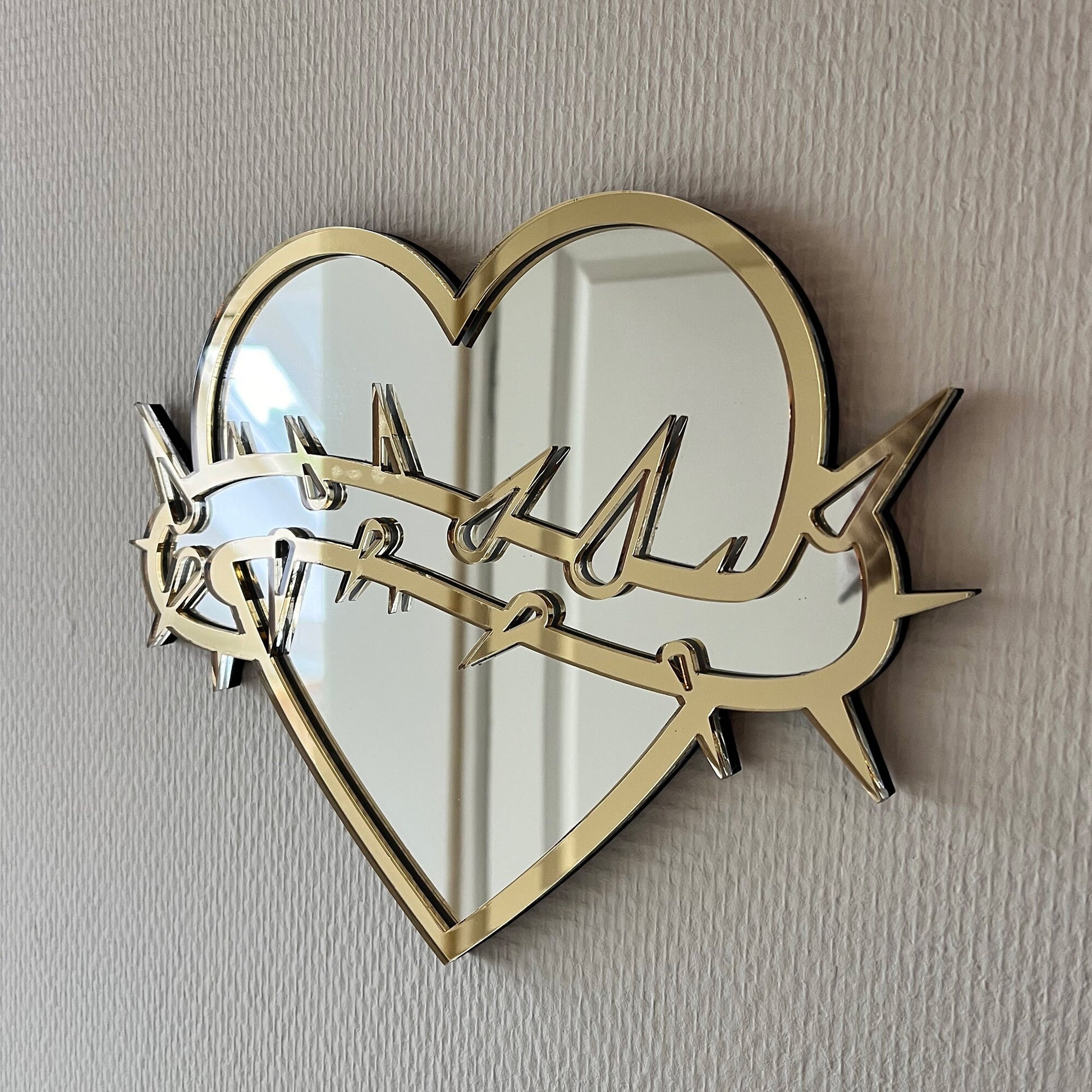 Lekky Studio&#39;s Exclusive Heart Mirror: Unique thorn design in traditional tattoo style, with luxurious gold and silver accents. Size: 29x22cm. Hand-assembled, laser-cut acrylic for a bespoke artistic touch to your decor.