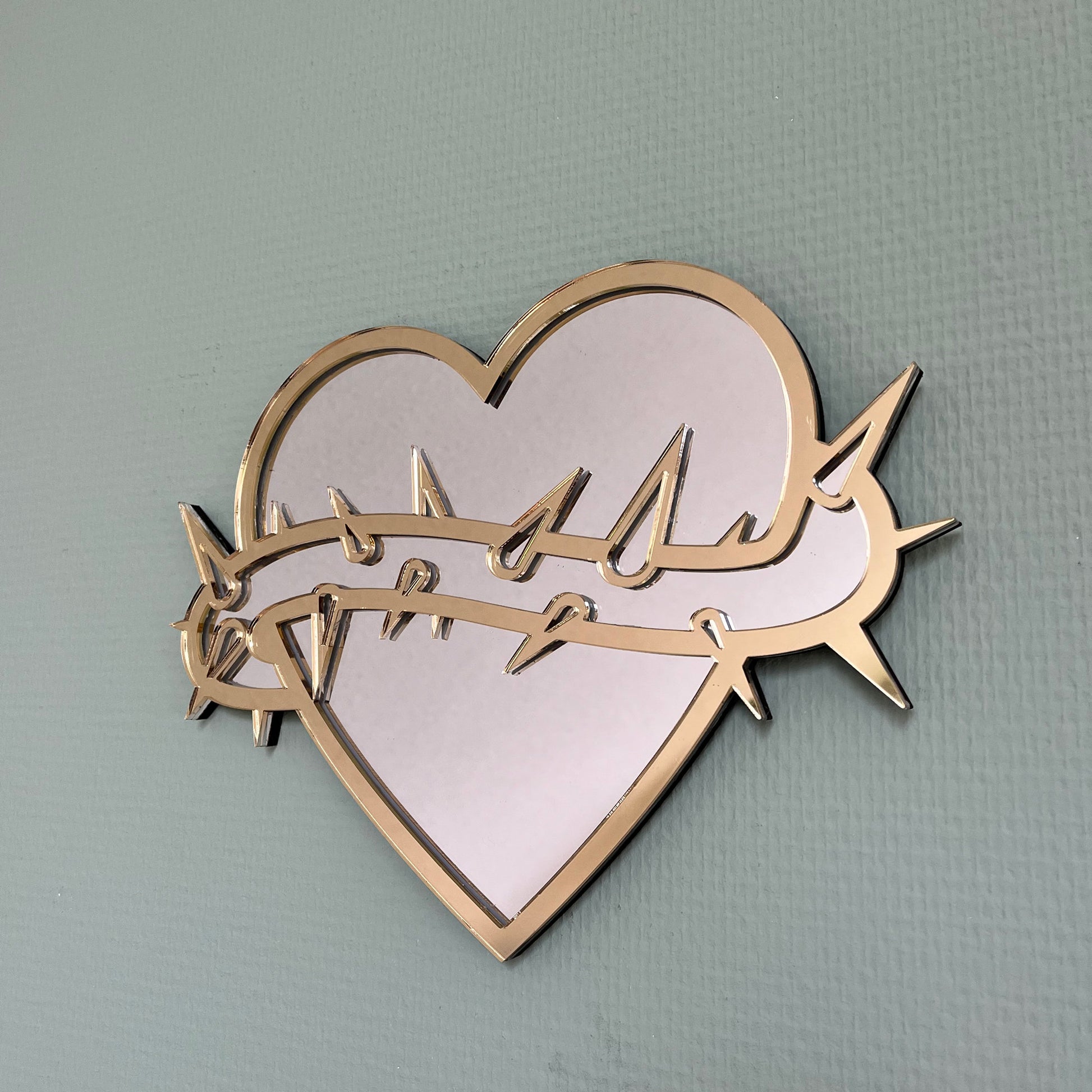 Lekky Studio&#39;s Exclusive Heart Mirror: Unique thorn design in traditional tattoo style, with luxurious gold and silver accents. Size: 29x22cm. Hand-assembled, laser-cut acrylic for a bespoke artistic touch to your decor.