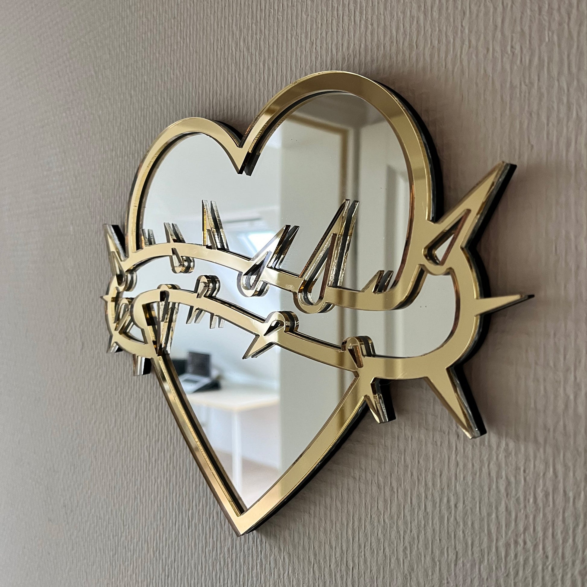 Lekky Studio&#39;s Exclusive Heart Mirror: Unique thorn design in traditional tattoo style, with luxurious gold and silver accents. Size: 29x22cm. Hand-assembled, laser-cut acrylic for a bespoke artistic touch to your decor.