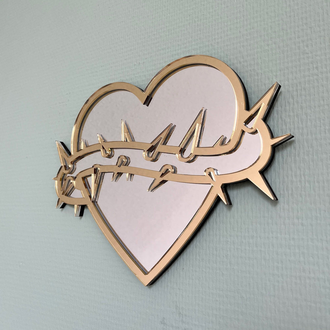 Lekky Studio&#39;s Exclusive Heart Mirror: Unique thorn design in traditional tattoo style, with luxurious gold and silver accents. Size: 29x22cm. Hand-assembled, laser-cut acrylic for a bespoke artistic touch to your decor.