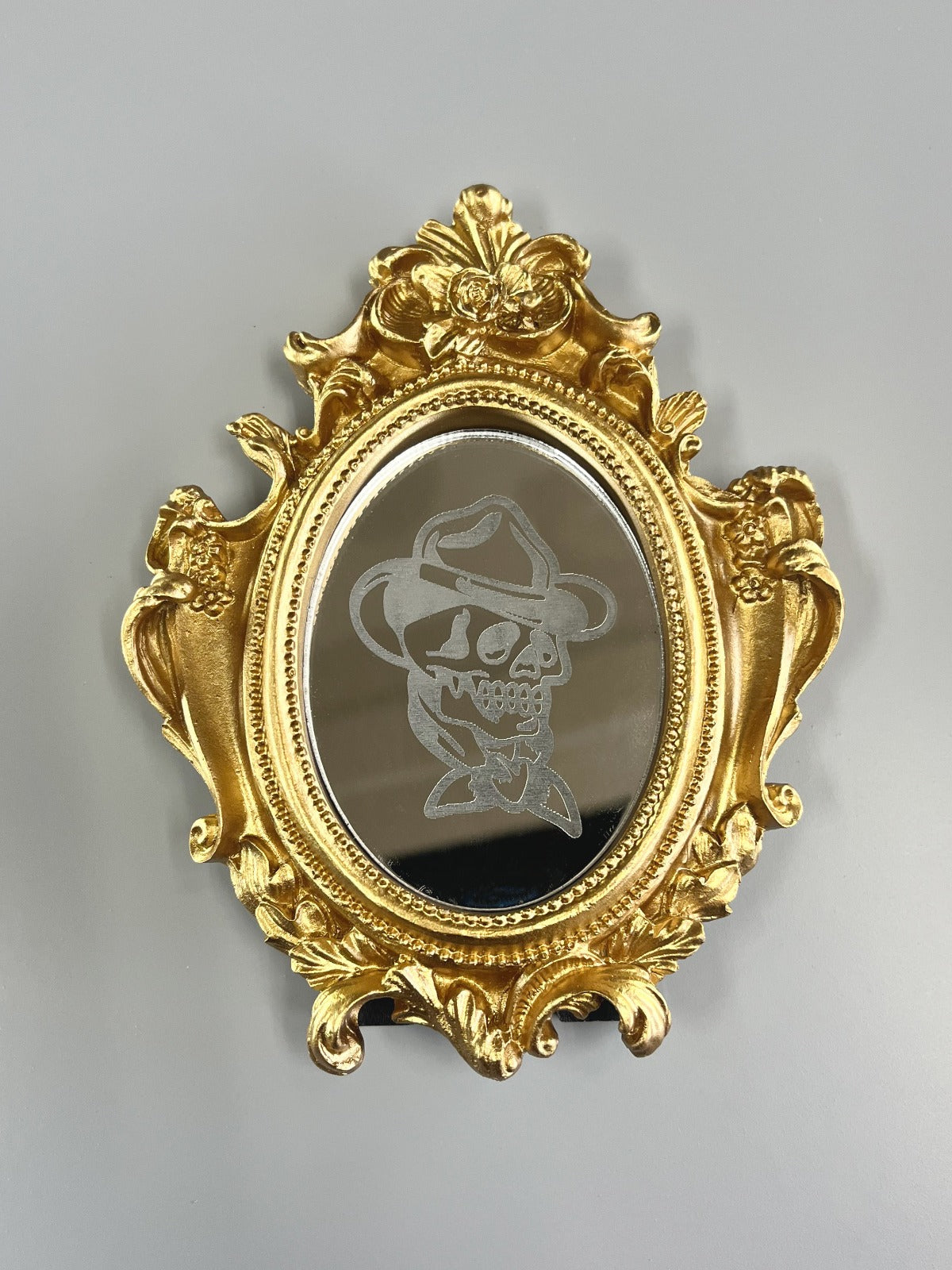 Gegraveerde acryl spiegel met cowboy skull tattoo in een kleine gouden vintage lijst.