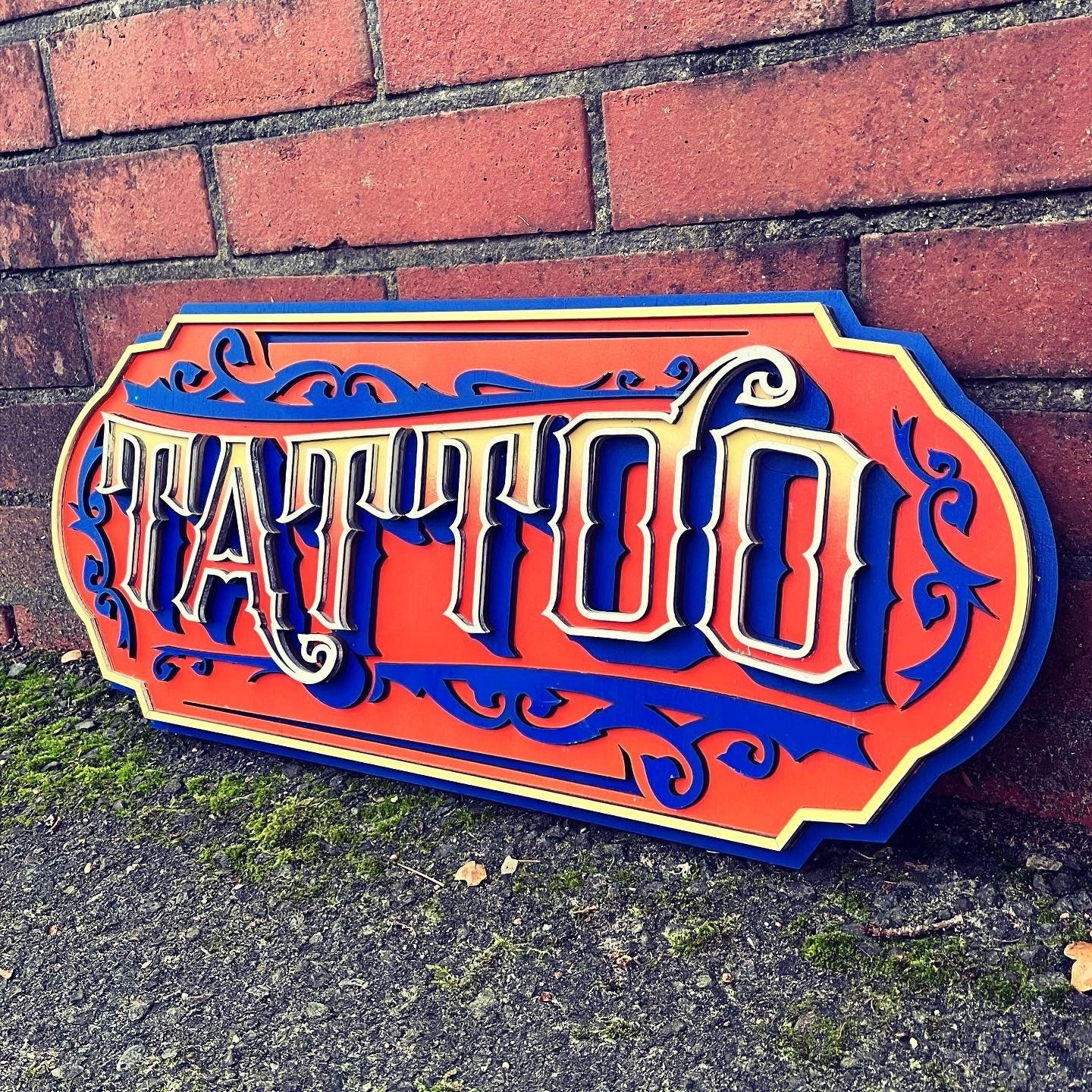 Handgemaakt houten Oranjestad Tattoo Sign met uniek design door Lekky Studio in Twente